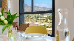 a table with a yellow chair and a window at ALLONBAY dream apartment in Villajoyosa