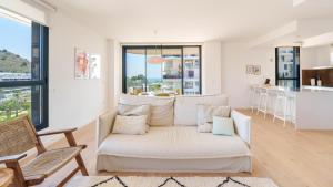 a living room with a white couch and a kitchen at ALLONBAY dream apartment in Villajoyosa