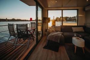 a living room with a couch and a table on a boat at Floatinghouse Enola in Fürstenberg