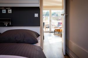 a bedroom with a bed and a door to a balcony at Floatinghouse Bellini in Klitten
