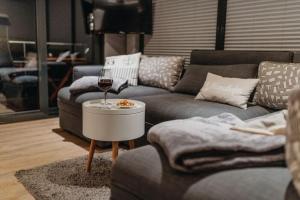 a living room with two couches and a glass of wine at Floatinghouse Enola in Fürstenberg