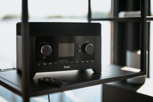 a black speaker on a shelf with a remote control at Floatinghouse Red Pearl in Zehdenick