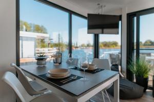 a dining room with a table with glasses of wine at Floatinghouse Red Pearl in Zehdenick