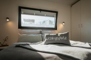 a bedroom with a bed with a large window at Floatinghouse Red Pearl in Zehdenick