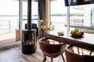 a wood burning stove in a dining room with a table at Floatinghouse Queen - LP6 in Vetschau