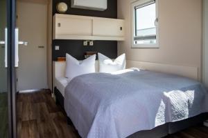 a bedroom with a large bed with white pillows at Floatinghouse Queen - LP6 in Vetschau
