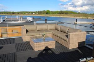a couch and a table on the deck of a boat at Floatinghouse Seensucht in Klitten