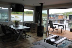 a living room with a couch and a table with a fireplace at Floatinghouse Seensucht in Klitten