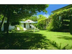 a yard with a slide and an umbrella and a house at Pension Iriomote in Iriomote