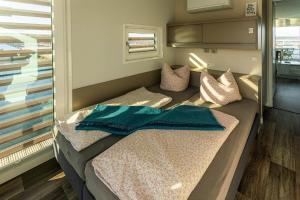 a bed in a small room with towels on it at Floatinghouse Paradise in Klitten