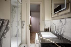 a bathroom with a sink and a glass shower at Aria Palace by OMNIA hotels in Rome