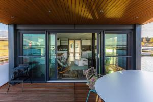 a balcony with glass doors and a table and chairs at Floatinghouse Paradise in Klitten