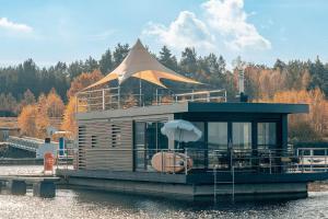 a small house on a boat in the water at Floatinghouse Paradise in Klitten