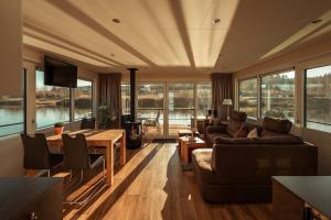 a living room with a couch and a table with chairs at Floatinghouse Möwenschiss in Klitten