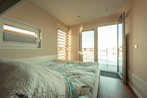 a bedroom with a bed and a large window at Floatinghouse Möwenschiss in Klitten