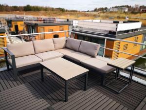 a couch and a table on the deck of a boat at Floatinghouse Schatzinsel in Klitten