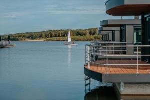a house on the water with a sail boat at Floatinghouse Seestern in Klitten