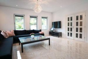 a living room with a black couch and a glass table at Villa Boomerang in Srbljani