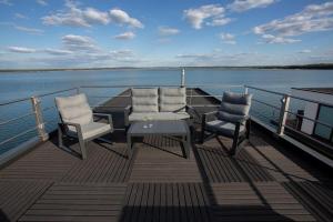 a deck of a boat with chairs and a table at Floatinghouse Dolce Vita - LP10 in Vetschau