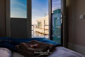 a bed with a towel on it in front of a window at Floatinghouse Arielle in Ribnitz-Damgarten