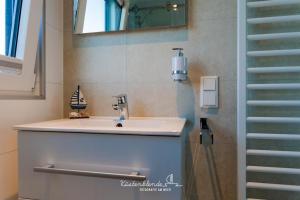 a bathroom with a sink and a mirror and a staircase at Floatinghouse Arielle in Ribnitz-Damgarten +21 photos