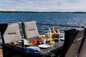a table with food and drinks on a boat on the water at Floatinghouse Arielle in Ribnitz-Damgarten