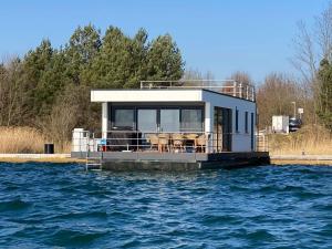 a houseboat on a dock on the water at Floatinghouse Seensucht - LP14 in Vetschau