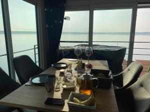 a wooden table with glasses of wine on a balcony at Floatinghouse Seensucht - LP14 in Vetschau