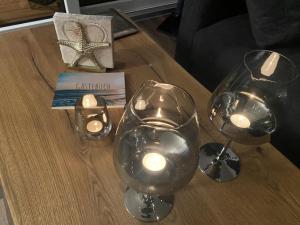 a table with two wine glasses and candles on it at Floatinghouse Seensucht - LP14 in Vetschau