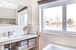 a white bathroom with a sink and a window at Floatinghouse Möwe 1 - LP1 in Vetschau