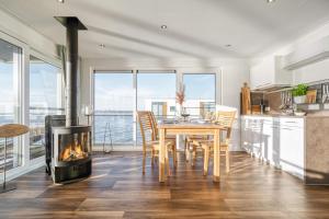 a kitchen and dining room with a table and a fireplace at Floatinghouse Mein Lieblingsboot in Ribnitz-Damgarten