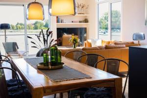 a living room with a wooden table and chairs at Floatinghouse Meerkraft in Ribnitz-Damgarten +23 photos