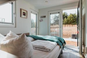 a bedroom with a bed and a sliding glass door at Floatinghouse Cosy Home - LP16 in Vetschau
