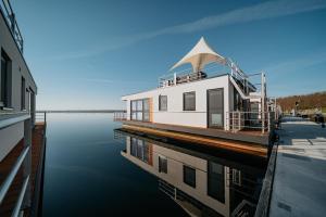 a large boat is sitting on the water at Floatinghouse Seeblick - LP7 in Vetschau
