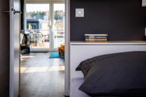 a bedroom with a bed and a view of a living room at Floatinghouse Malibu Sunrise in Klitten
