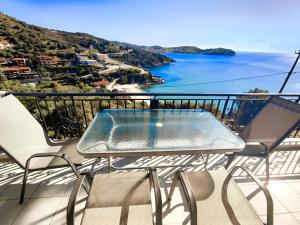 a table on a balcony with a view of the ocean at Aegean Beachfront Apartments in Petriaí +11 photos
