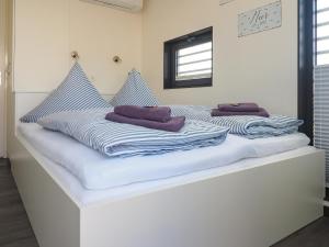 a white bed with blue and white towels on it at Floatinghouse Krosse Krabbe - LP6 in Peenemünde