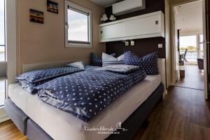 a bed with blue pillows on it in a room at Floatinghouse Dory in Ribnitz-Damgarten