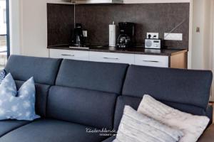 a blue couch with pillows in a kitchen at Floatinghouse Dory in Ribnitz-Damgarten