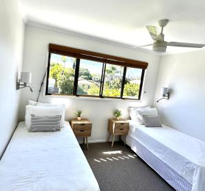 two beds in a room with two windows at Waterfront Retreat Mooloolaba in Mooloolaba +3 photos