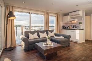 a living room with a couch and a table at Floatinghouse Möwe 4 - LP4 in Vetschau