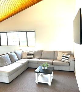 a living room with a couch and a coffee table at Waterfront Retreat Mooloolaba in Mooloolaba