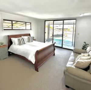 a bedroom with a bed and a couch at Waterfront Retreat Mooloolaba in Mooloolaba