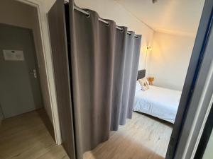 a room with a metal partition with a bed at Le central in Balaruc-les-Bains