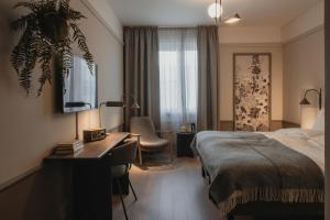 a hotel room with a bed and a desk at Home Hotel Victoria in Jönköping +103 photos