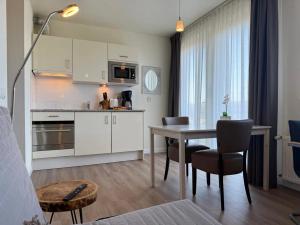 eine Küche und ein Esszimmer mit Tisch und Stühlen in der Unterkunft Hotel Rasch in Bergen aan Zee