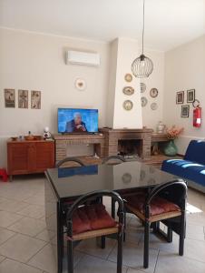 a living room with a table and a tv at a casa di Norma in Bronte