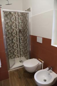 a bathroom with a shower and a toilet and a sink at Casetta Amati 2 in Nettuno +27 photos