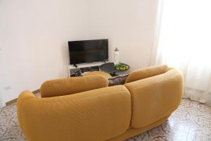 a living room with a couch and a tv at Casetta Amati 2 in Nettuno