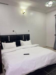a large white bed with white sheets and pillows at Shana Homes in Karsana